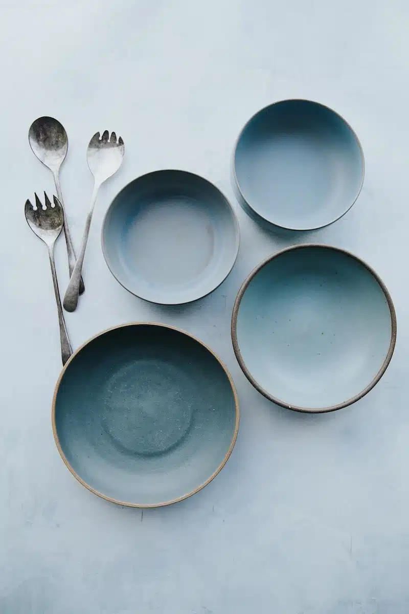 four assorted blue plates on white surface